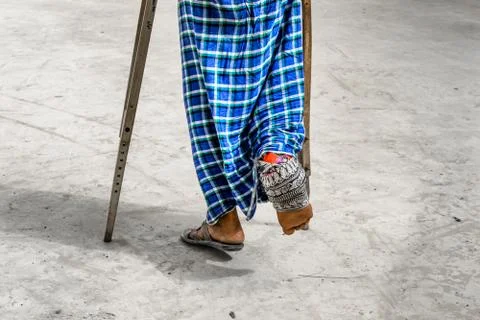 A paralyzed man walking by support of walking sticks 스톡 사진