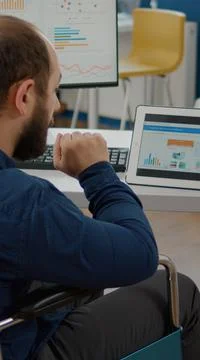 Paralyzed manager man using computer and tablet in same time Stock Photos