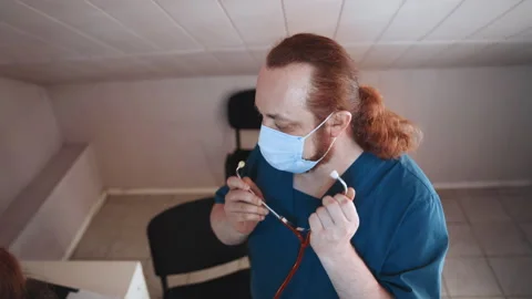 Paramedic in attic setting preparing medical tools calmly. Healthcare provider 動画素材 342337463