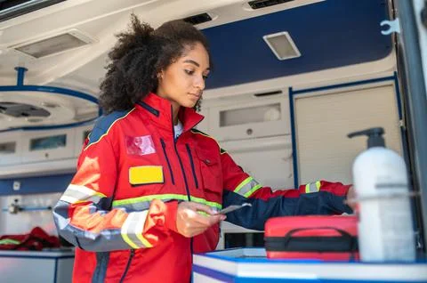Paramedic checking for availability of pharmaceuticals in the ambulance car Foto stock