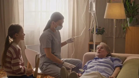 Paramedic Checking Drip while Senior Woman Communicating with Her Stock Footage 335883614