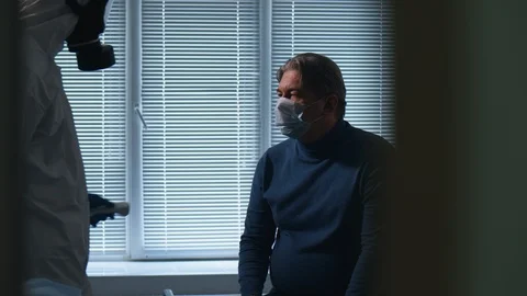 Paramedic is checking man's temperature with a modern device Stock Footage 128198567