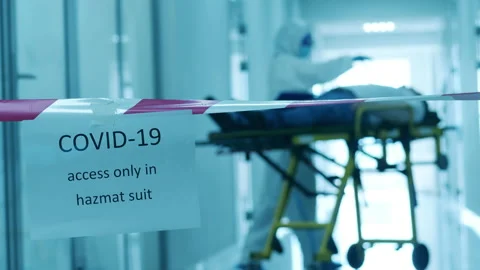 Paramedic is checking up a patient in a quarantined corridor. COVID-19 patient Stock Footage 130880357