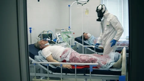 Paramedic is checking temperature of a man in an oxygen mask Stock Footage 128197570