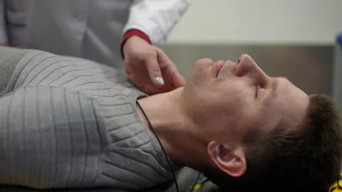 A paramedic checks the pulse of a bedridden man in an ambulance. 스톡 동영상 254193169