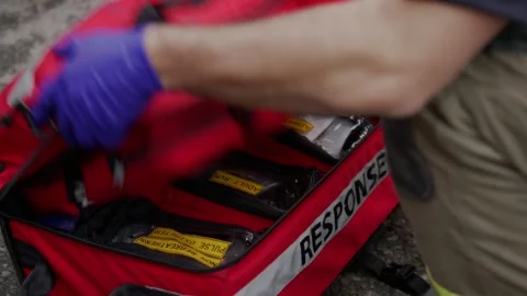 A paramedic first responder opens up their emergency travel kit filled with 스톡 동영상 308625665