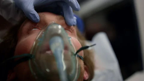 Paramedic hand checking man with flashlight. Doctor examining male patient Stock Footage 166866296