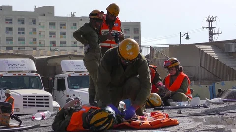 Paramedic of Homeland Security force give first aid to victim of earthquake Stock Footage 75797652