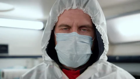 Paramedic looking at camera in emergency car. Doctor wearing protective suit 스톡 동영상 166866140