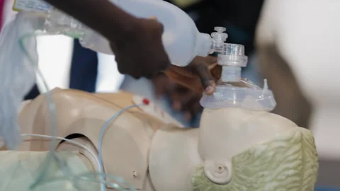 Paramedic practicing bag-valve-mask ventilation on a dummy Video stock 332586288