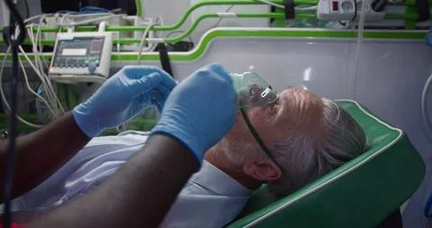 Paramedic saving life of old man in ambulance. Medic giving oxygen to patient Stock Footage 158309928
