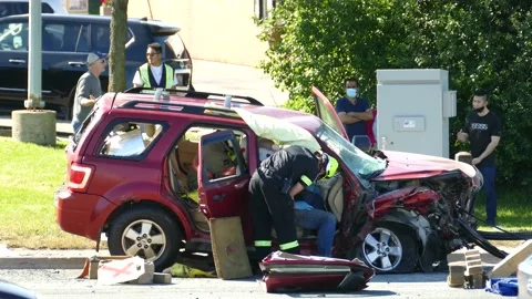 Paramedic standing next to passenger sitting in SUV with ripped off car door Video stock 133972161