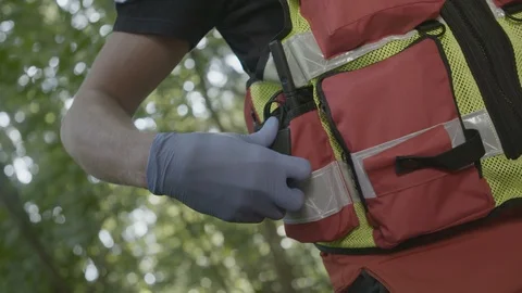 Paramedic is taking out handheld two-way radio Stockbeeldmateriaal 99807530