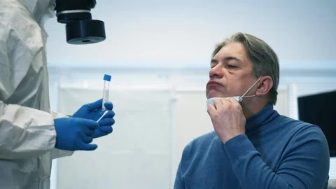 Paramedic is taking patient's saliva for testing. Infection, covid-19 pandemic Stock Footage 128199535