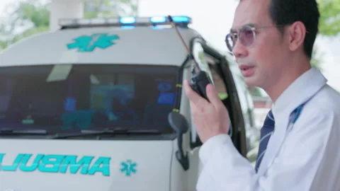 A paramedic talks on the radio while closing the ambulance door to drive to the  Stock Footage 209924914