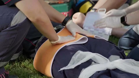 Paramedic trainees apply a pelvic binder to a patient simulator during Stock Footage 337690804