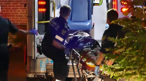 Paramedic Transports Wounded Victim into an Ambulance Stock Footage