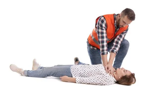 Paramedic in uniform performing first aid on unconscious woman against white  写真素材