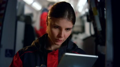 Paramedic using digital tablet at work. Medic browsing internet online on pad Stock Footage 166877709