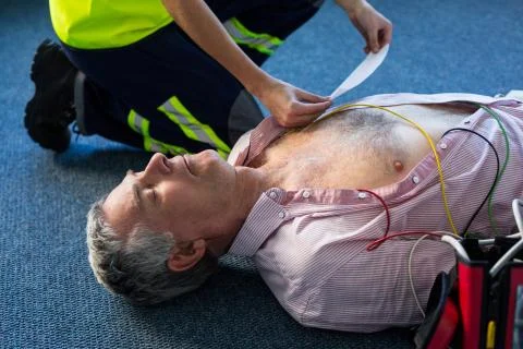 Paramedic using an external defibrillator during cardiopulmonary resuscitatio Foto stock