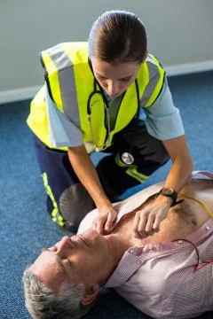 Paramedic using an external defibrillator during cardiopulmonary resuscitatio Foto stock