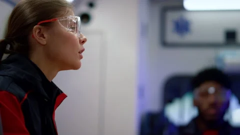 Paramedic using phone in emergency car. Doctor discussing work with colleague Stock Footage 166893680