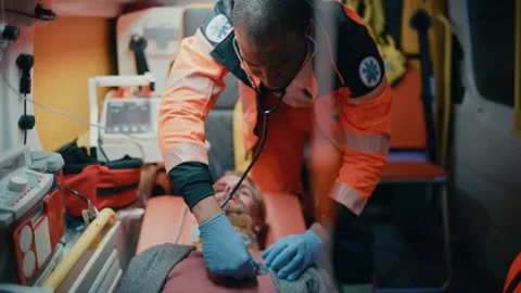 Paramedic Using Stethoscope on Patient in Ambulance Stock-Footage 141569783