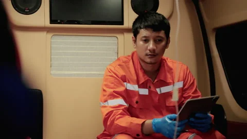 Paramedic worker is sitting in a car to pick up a patient with a tense Stock Footage 197330341