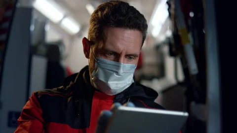 Paramedic working on digital tablet. Doctor scrolling internet pages on tablet 스톡 동영상 166879444