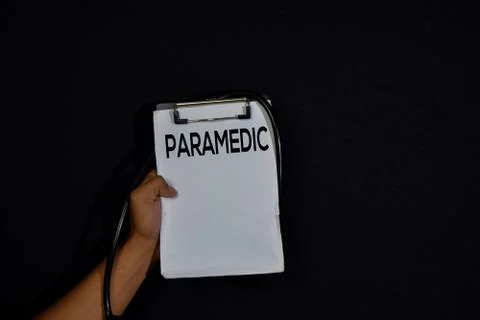 Paramedic write on paperwork isolated on dark black background. Stock Photos