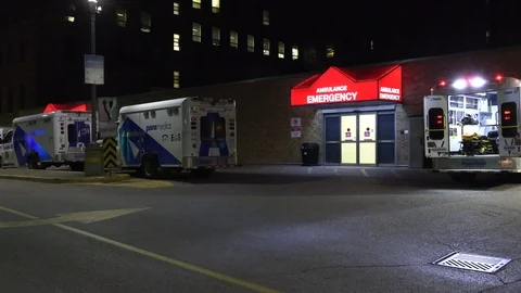 Paramedics ambulances lined up at emergency at trauma hospital Stock Footage 118561663