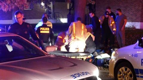 Paramedics and firemen help shooting victim while cops stand around Video stock 97361927