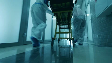 Paramedics are pushing a rolling table along the hall Stock Footage 130878570