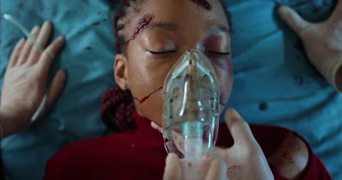 Paramedics checking heart rate and putting on oxygen inhalation mask on young Stock Footage 139693060