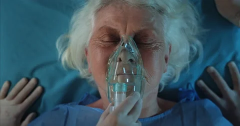 Paramedics checking pulse and putting oxygen inhalation mask on old lady face Video stock 139153698