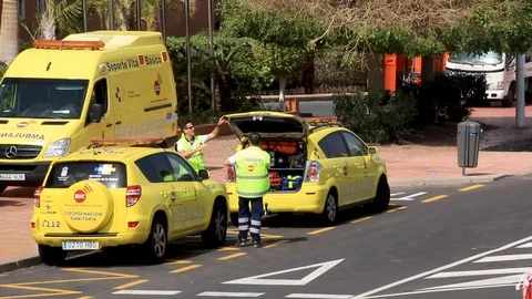 Paramedics close trunk of ambulance in front of Adeje Palace hotel Tenefire 動画素材 125730861