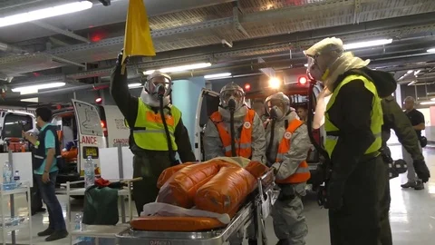 Paramedics dressing protective suits unload injured manikins from ambulance Stock Footage 81425418