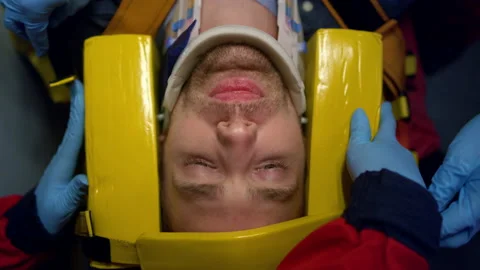 Paramedics hands taking care about patient. Doctors fixing man head on stretcher Stock Footage 166884606