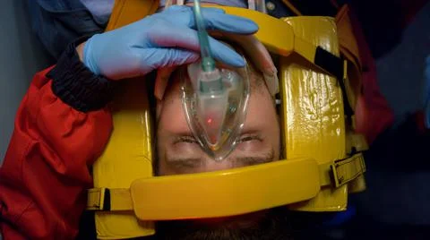 Paramedics proving first aid help to man. Doctors putting oxygen mask on patient 스톡 사진