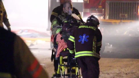Paramedics pulling away injured fireman towards bright light 스톡 동영상 40602275