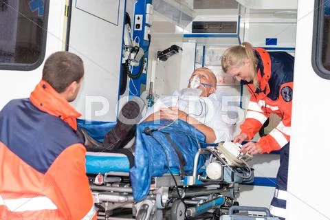 Paramedics putting patient in ambulance car aid Stock Photos