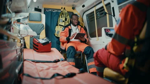 Paramedics Riding in Ambulance Using Tablet Stock Footage 141568627