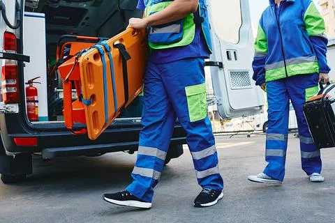 Paramedics rush to call and quickly walk outside with stretchers and first .. Stock Photos