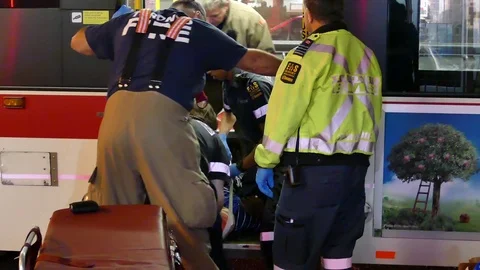 Paramedics stabilizing patient on spinal board at bus crash Video stock 77899044