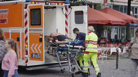Paramedics work with a stretcher giving first aid to patient at Altstadt square  Stock Footage 246390071