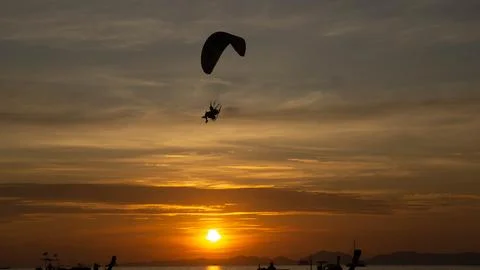Paramotor during a vibrant orange sunset in the beach, in Ao Nang, Thailand. Stock Photos