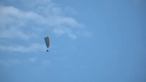 Paramotor flying in a blue sky. pilot flying in sky man hang glider parachute Stock Footage 196717871