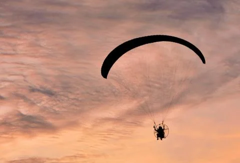 Paramotor flying on the sky sunset background Stock Photos