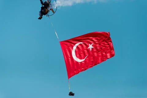 Paramotor jumper on the sky with a huge Turkish flag on the liberty day of Iz Stock Photos