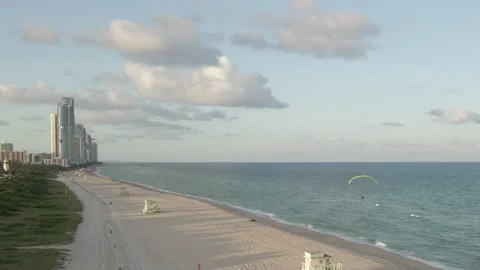 Paramotor man flies over Haulover Beach on quiet afternoon in Miami 動画素材 167984506